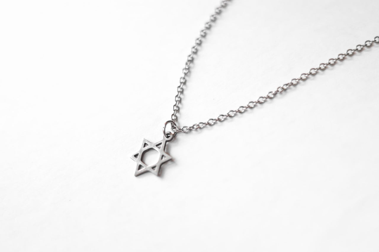A silver Star of David necklace with a stainless steel chain, displayed against a white background.