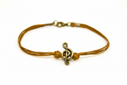 Bracelet with a bronze music note charm on a white background