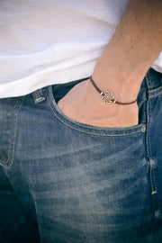 Karma bracelet for men with a silver braided circle charm, brown cord