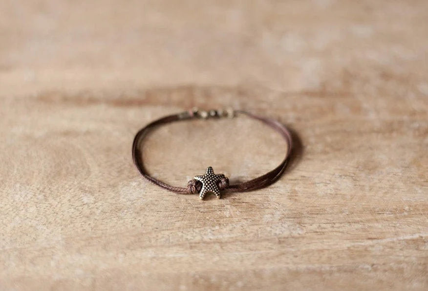 Bracelet with a starfish charm on a wooden surface