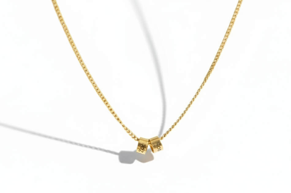 Gold necklace with a small pendant on a white background