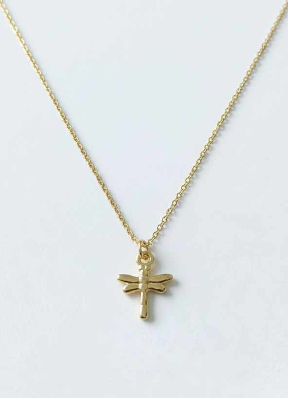 Gold bracelet with a dragonfly charm on a white background