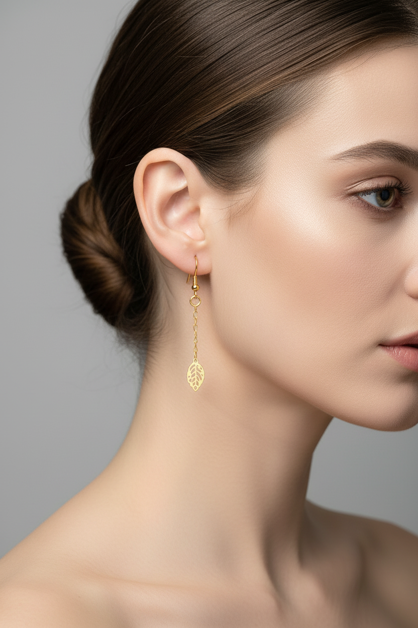 Close-up of a woman wearing gold earrings with a neutral background