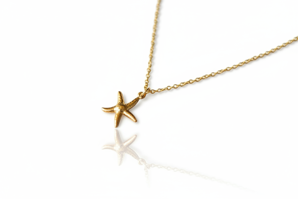 Gold starfish pendant necklace on a white background