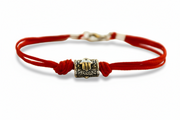 Red string bracelet hamsa bead with a silver clasp on a white background