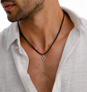 Man wearing a white shirt with a Star of David necklace.