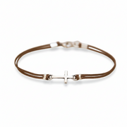 Brown leather bracelet with a silver cross charm on a white background