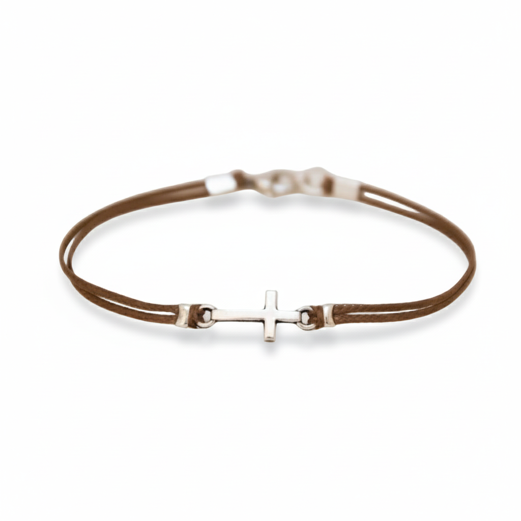 Brown leather bracelet with a silver cross charm on a white background
