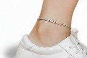 Silver chain anklet on a person's ankle with a white sneaker