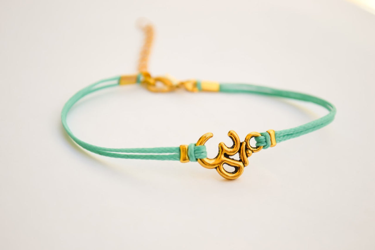 Turquoise bracelet with gold tone Om charm - shani-adi-jewerly