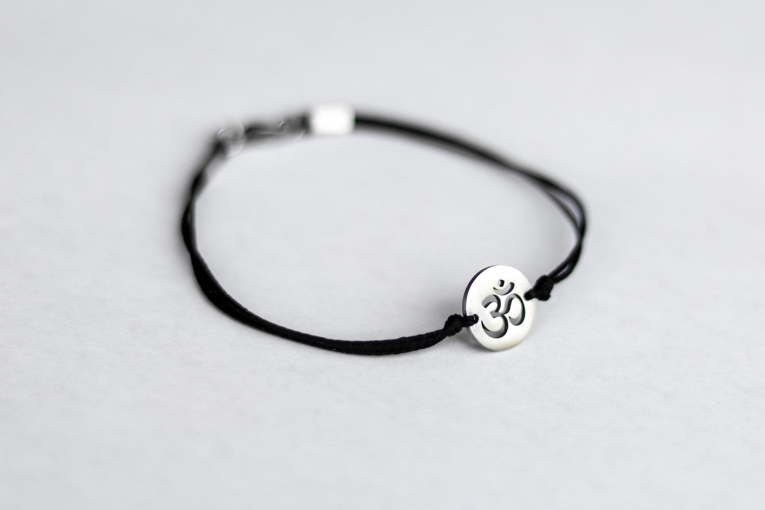 handmade silver om bracelet for men, black cord - shani and adi jewelry